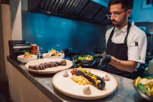 Main course being prepared by a chef at Criollo Restaurant